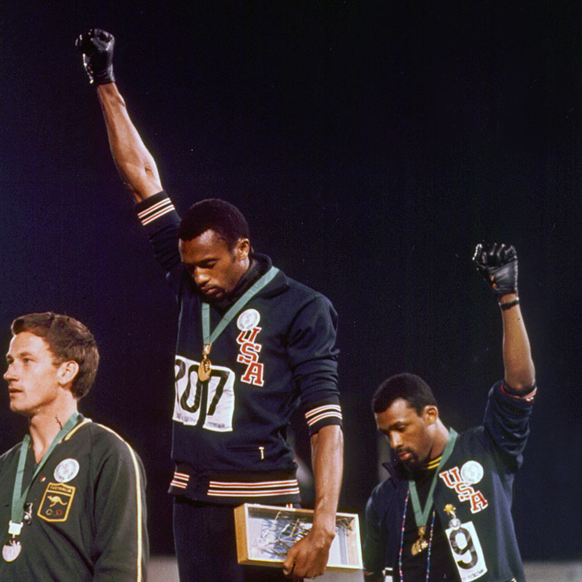 1968 Olympics Black Power salute raised by the African-American athletes Tommie Smith and John Carlos during their medal ceremony at the 1968 Summer Olympics in the Olympic Stadium in Mexico City. As they turned to face their flags and hear the American national anthem, they each raised a black-gloved fist and kept them raised until the anthem had finished