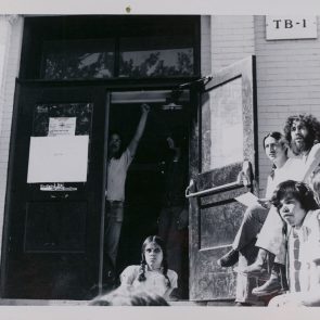 Picture of students standing and sitting outside of TB-1