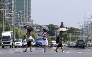 people cross the road in Mirae Scientist Street of Pyongyang, North Korea, on Wednesday, July 21, 2021