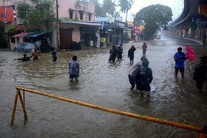 CORRECTS TO STORM MICHAUNG - People wade through a flooded street following heavy rains along the Bay of Bengal coast in Chennai, India, Monday, Dec.4, 2023. Authorities issued warnings for tropical storm Michaung, which is likely to hit the southern coast on Tuesday with maximum sustained winds of 90-100 kilometers (56-62 miles) per hour with gusts up to 110 kph (68 mph), the Indian Meteorological Department said. (AP Photo)