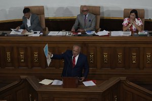 Venezuelan lawmaker Diosdado Cabello holds the new map of Venezuela with the Essequibo territory, a large swath of land that is administered and controlled by Guyana but claimed by Venezuela, during a session at the National Assembly in Caracas, Venezuela, Wednesday, Dec. 6, 2023.