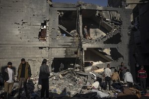 Palestinians look at houses destroyed in the Israeli bombardment of the Gaza Strip in Rafah on Saturday, Dec. 9, 2023.