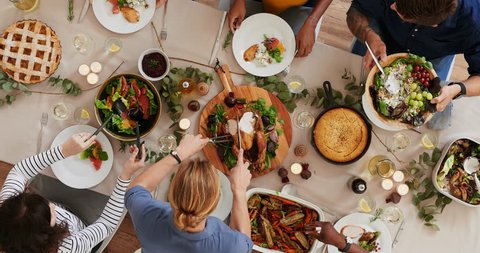 top view of woman carving thanksgiving  turkey young cheerful multi ethnic friends preparing table enjoying vibrant festive season meal together talking bonding over healthy food time lapse rotate Stock Video