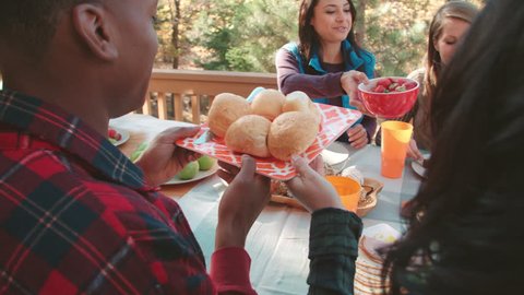 Over shoulder view of friends eating at a table outdoors Stock Video