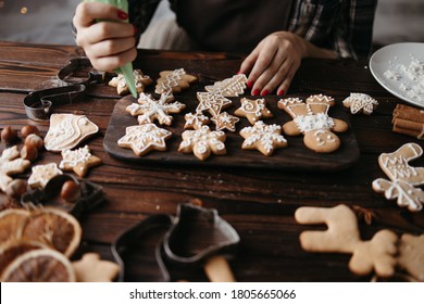 Christmas, New Year, DIY, holidays preparation and creativity concept. Getting ready to celebration. Woman hands decorating homemade gingerbread cookies with icing Stock Photo