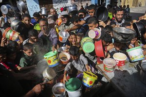 File - Palestinians crowd together as they wait for food distribution in Rafah, southern Gaza Strip, on Nov. 8, 2023.