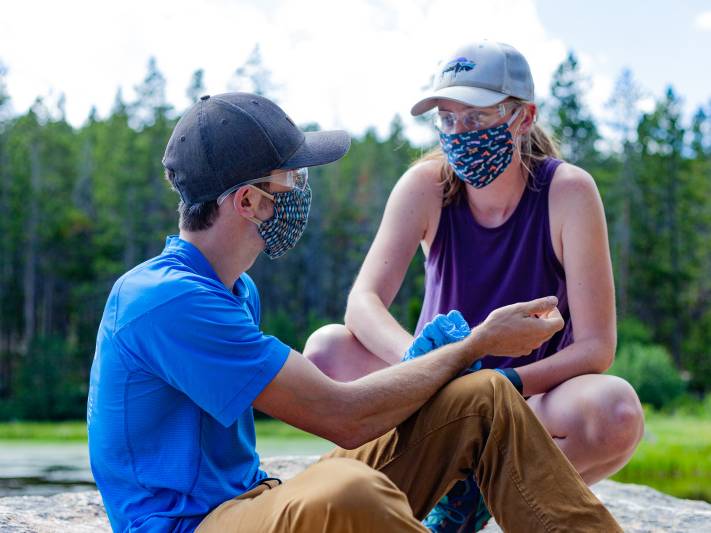 Woman checks the pulse of a participant in a practice scenario