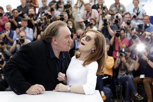 Actor Gerard Depardieu, left, tries to kiss actress Isabelle Huppert during a photo call for the film Valley of Love, at the 68th international film festival, Cannes, southern France, Friday, May 22, 2015