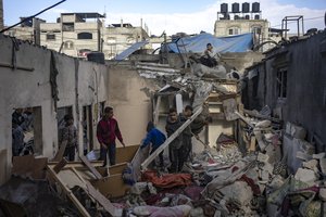 Palestinians inspect a house after it was hit by an Israeli bombardment on Rafah, southern Gaza Strip, Thursday, Dec. 14, 2023.