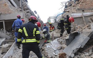 In this photo provided by the Ukrainian Emergency Service, emergency personnel work at the scene following a drone attack in the town of Rzhyshchiv, Kyiv region, Ukraine, Wednesday, March 22, 2023