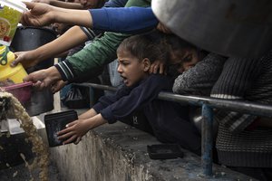 Palestinians line up for a free meal in Rafah, Gaza Strip, Thursday, Dec. 21, 2023. International aid agencies say Gaza is suffering from shortages of food, medicine and other basic supplies as a result of the two and a half month war between Israel and Hamas.