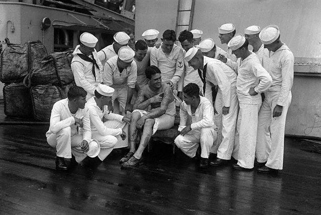 Storytelling time aboard the U.S.S. Texas found S.O. Buchanan, tattooed wonder of the crew, surrounded by shipmates --1928.