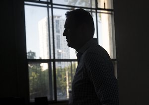 Russian opposition activist Alexei Navalny leaves a court after a hearing in Moscow, Russia