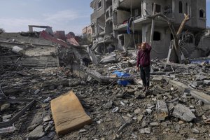 Palestinians inspect the rubble of a building of the Al Nawasrah family destroyed in an Israeli strike in Maghazi refugee camp, central Gaza Strip, Monday, Dec. 25, 2023.