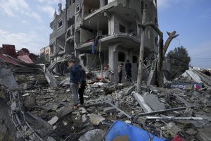 Palestinians inspect the rubble of a building of the Al Nawasrah family destroyed in an Israeli strike in Maghazi refugee camp, central Gaza Strip, Monday, Dec. 25, 2023.