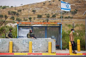 Israeli soldiers guard a bus station at the Tapuach junction next to the West Bank city of Nablus, Tuesday, June 30, 2020.