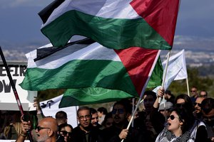 Demonstrators shout slogans and hold placards, condemning Israel's military operations inside the Gaza strip, outside the entrance of RAF Akrotiri, near southern port city of Limassol, Cyprus, on Sunday, Jan. 14, 2024.