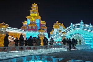 Tourists look at an ice sculpture as they visit the annual Harbin Ice and Snow World in Harbin in northeastern China's Heilongjiang Province