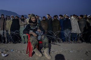 A Taliban fighter stands guard as Afghan refugees line up to register in a camp near the Pakistan-Afghanistan border in Torkham, Afghanistan, Saturday, Nov. 4, 2023. Many Afghans have lived for decades in Pakistan, driven there by successive wars at home. When the order was announced, hundreds of thousands feared arrest and fled back to Afghanistan. Often Pakistani authorities prevented them from taking anything with them, they say.