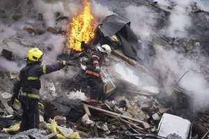 Rescuers work the scene of a building damaged by Russian rocket attack in Kharkiv, Ukraine, Tuesday, Jan. 23, 2024