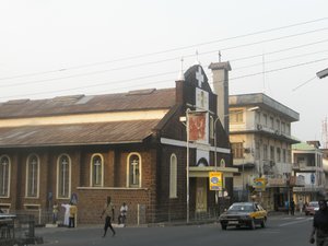 Taxi car in the middle of Siaka Stevens street, the Saint Joesph's Catholic Church on the left.