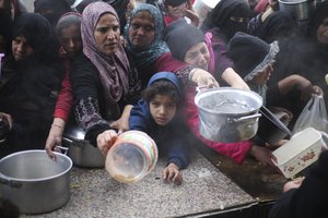 Palestinians line up for free food distribution during the ongoing Israeli air and ground offensive in Khan Younis, Gaza Strip, Friday, Feb. 2, 2024.