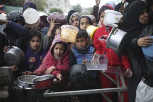 Palestinians line up for free food distribution during the ongoing Israeli air and ground offensive in Khan Younis, Gaza Strip, Friday, Feb. 2, 2024.