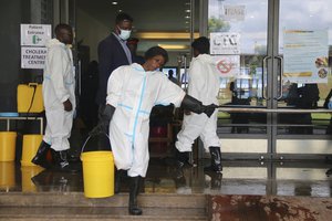 File - A worker carries a bucketfull of disinfectant at a cholera treatment centre, in Lusaka, Zambia, Friday, Jan 12, 2024. The country is reeling from a major cholera outbreak that has killed more than 400 people and infected more than 10,000, leading authorities to order schools across the country to remain shut after the end-of-year holidays.