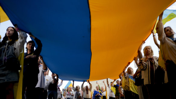 People hold a Ukrainian flag in Buenos Aires, Argentina on Saturday to mark the second anniversary of Russia’s invasion of Ukraine.