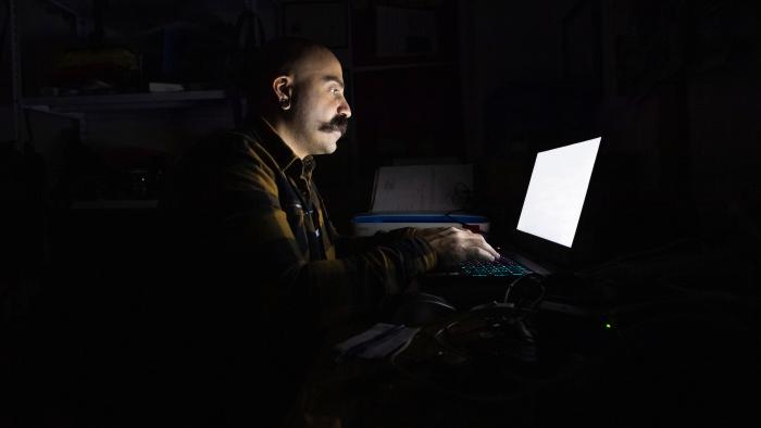 Man in a dark room on a laptop