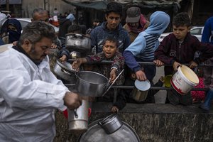 Palestinians line up for free food in Rafah, Gaza Strip, Friday, Feb. 23, 2024. An estimated 1.5 million Palestinians displaced by the war took refuge in Rafahor, which is likely Israel's next focus in its war against Hamas.