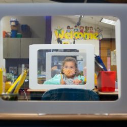 A second-grade student works behind a protection shield at a socially distanced desk at Wesley Elementary School.