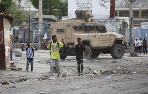 Youths raise their hands to show police they are not carrying weapons during an anti-gang operation at the Portail neighborhood in Port-au-Prince, Haiti, Thursday, Feb. 29, 2024. Gunmen shot at the international airport and other targets in a wave of violence that forced businesses, government agencies and schools to close early.