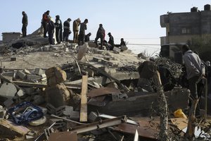 Palestinians look at the destruction after an Israeli strike on a residential building in Rafah, Gaza Strip, Sunday, March 3, 2024.