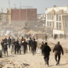 Palestinians carry bags of flour received from an aid truck that arrived in the west of Gaza City on March 6.