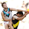 Tim Taranto of the Tigers and Dylan Williams of the Power collide at the MCG on Sunday.