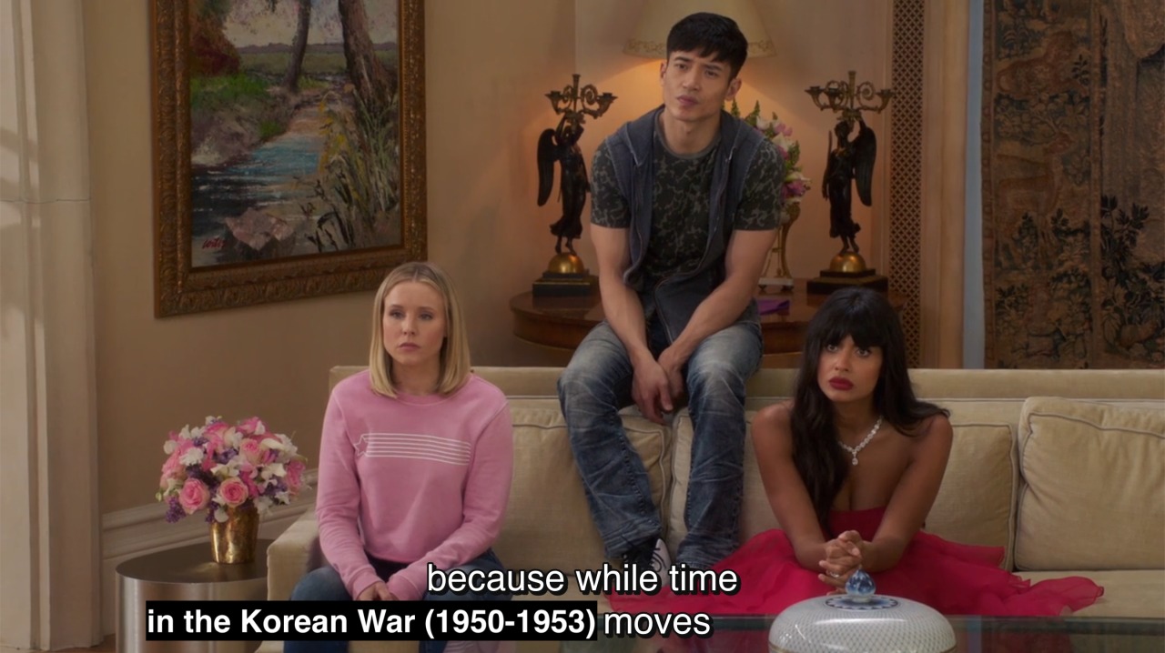 Reaction shot of Eleanor, Jason, and Tahani looking confused while Michael continues “because while time in the Korean War (1950-1953) moves…”