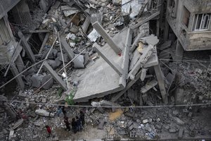 Palestinians inspect the damage of residential buildings after an Israeli airstrike in Rafah, southern Gaza Strip, Sunday, March 24, 2024.