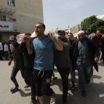 Relatives of Palestinians killed in Israeli airstrikes carry the bodies of their loves ones from the morgue at al-Aqsa Hospital for burial, Deir al-Balah, March 27, 2024. (Photo: Ali Hamad/APA Images)