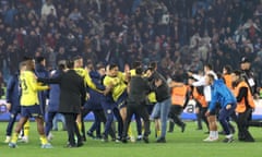 Trabzonspor fans invade the pitch and clash with Fenerbahce players and security staff after the Super Lig match between the two teams at Papara Park in Trabzon, Turkey on 17 March 2024