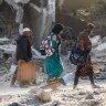 People inspect damage and remove items from their homes on Sunday after the IDF pulled out of Khan Younis.