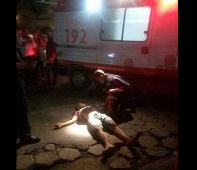 A paramedic attends to a man who is left on his back in the riots in Espírito Santo