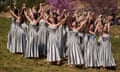 Women in matching dresses take part in a rehearsal