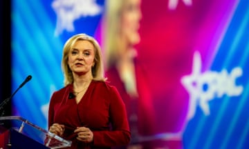 a woman speaks against a backdrop displaying her face and "CPAC"