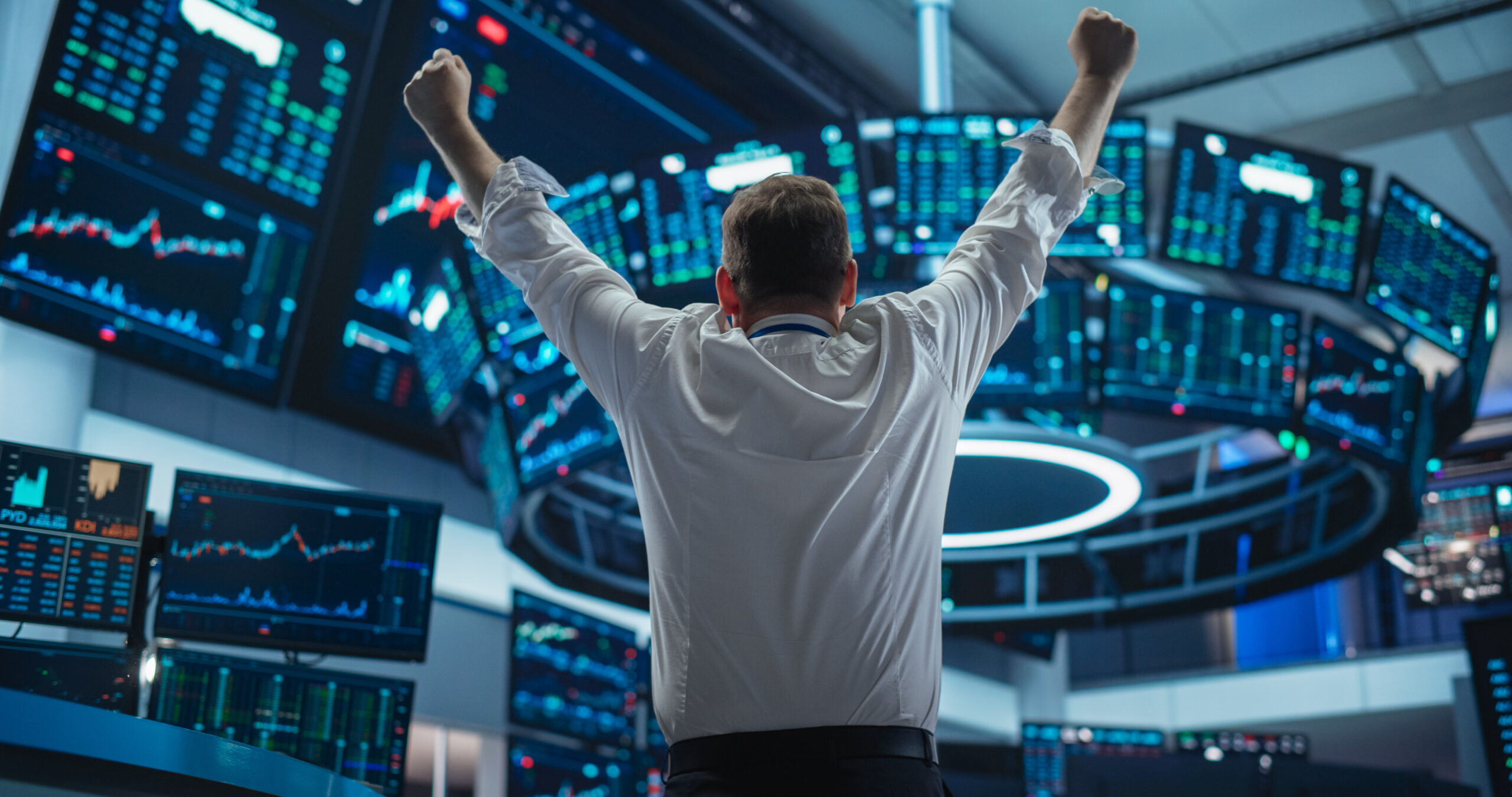 Excited Businessman Raises Hands and Punches Air while Celebrating Successful Deal. Stock Exchange Manager Happy After Investment Day. Broker in White Shirt Wins a Profitable Contract. Back View