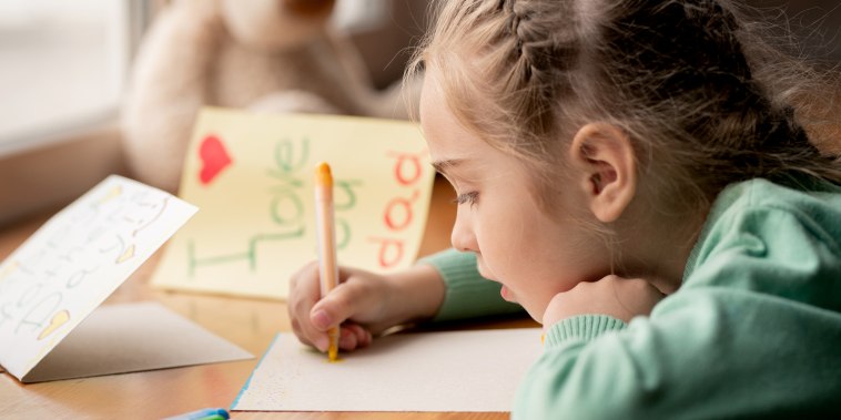 Concentrated girl making postcard for her dad