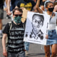 Demonstrators walk down Sable Boulevard during a rally and march over the death of Elijah McClain in Aurora, Colo., on June 27, 2020.