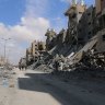 Palestinians pass the remains of buildings following the withdrawal of the Israeli military from Hamad City, west of Khan Younis, Gaza.