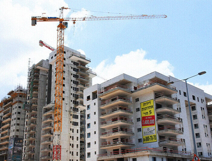 Buildings under construction with a crane in the foreground.