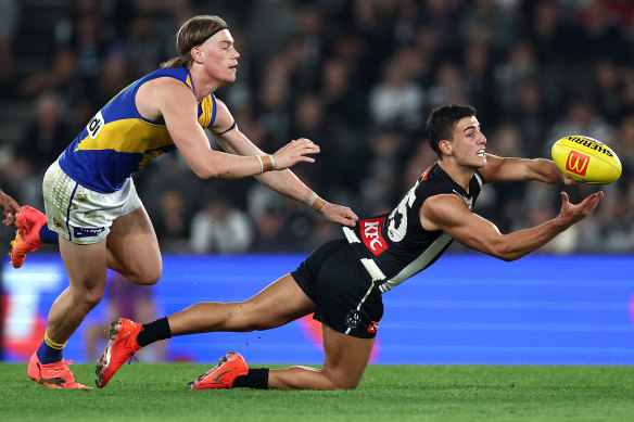 Nick Daicos of the Magpies handballs.